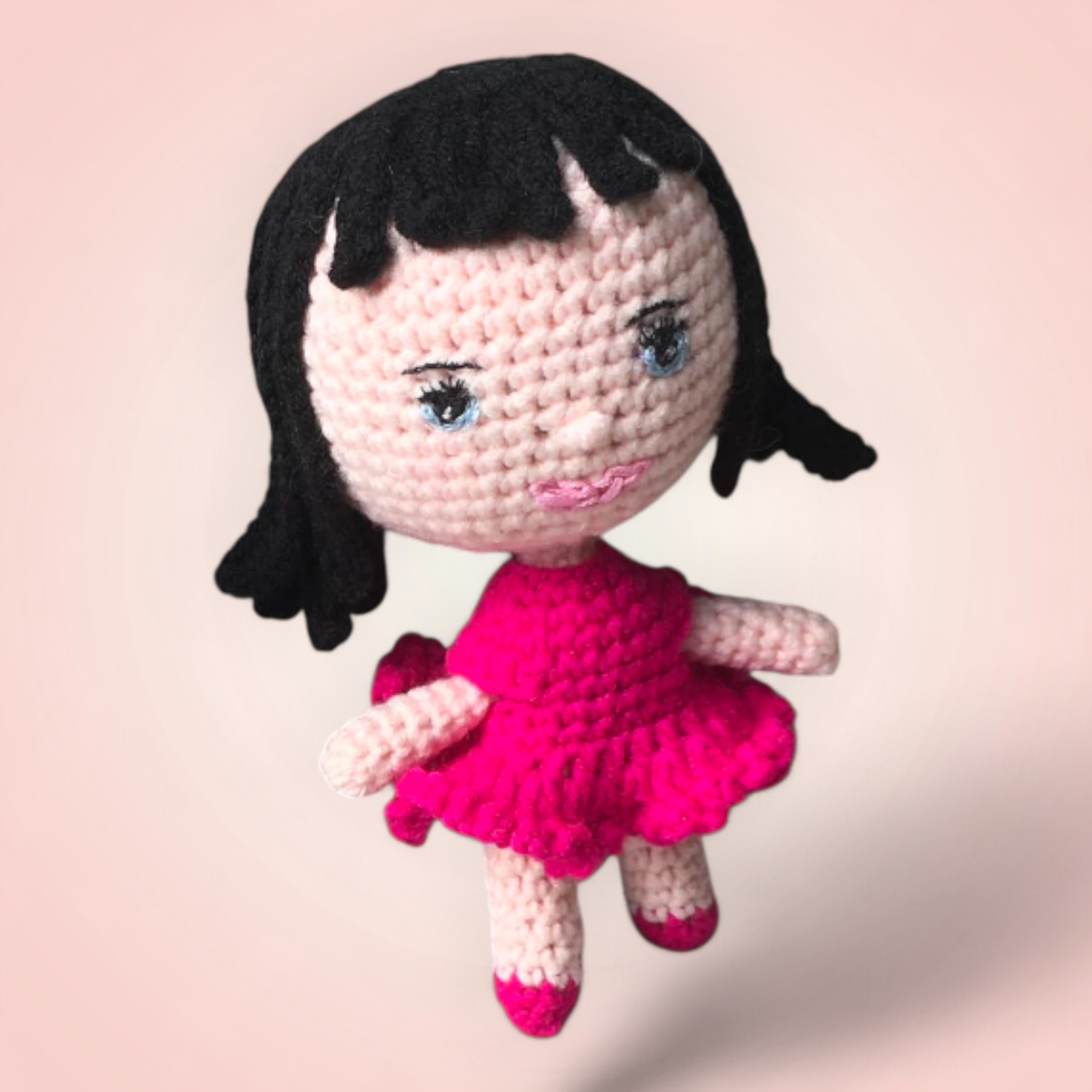 Adorable poupée rose en crochet.