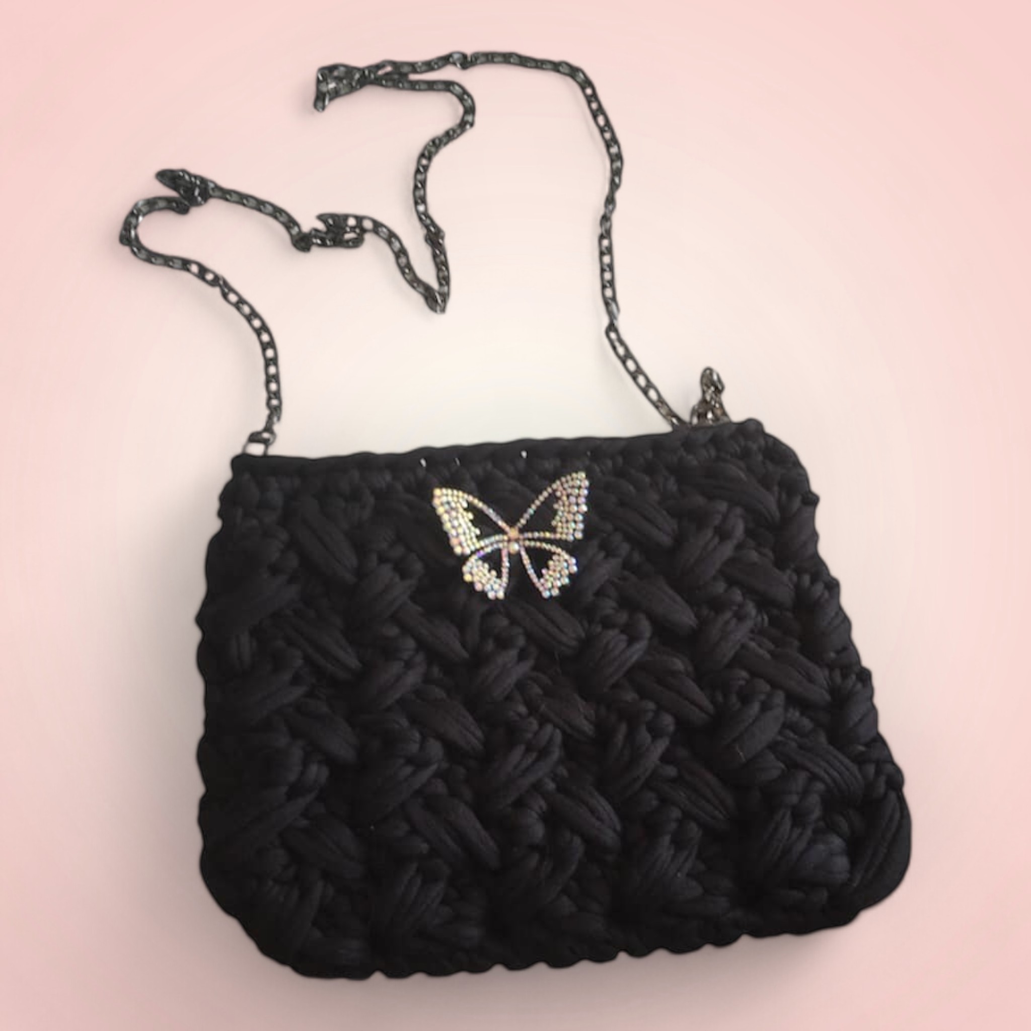 Sac à main noir avec broche papillon.