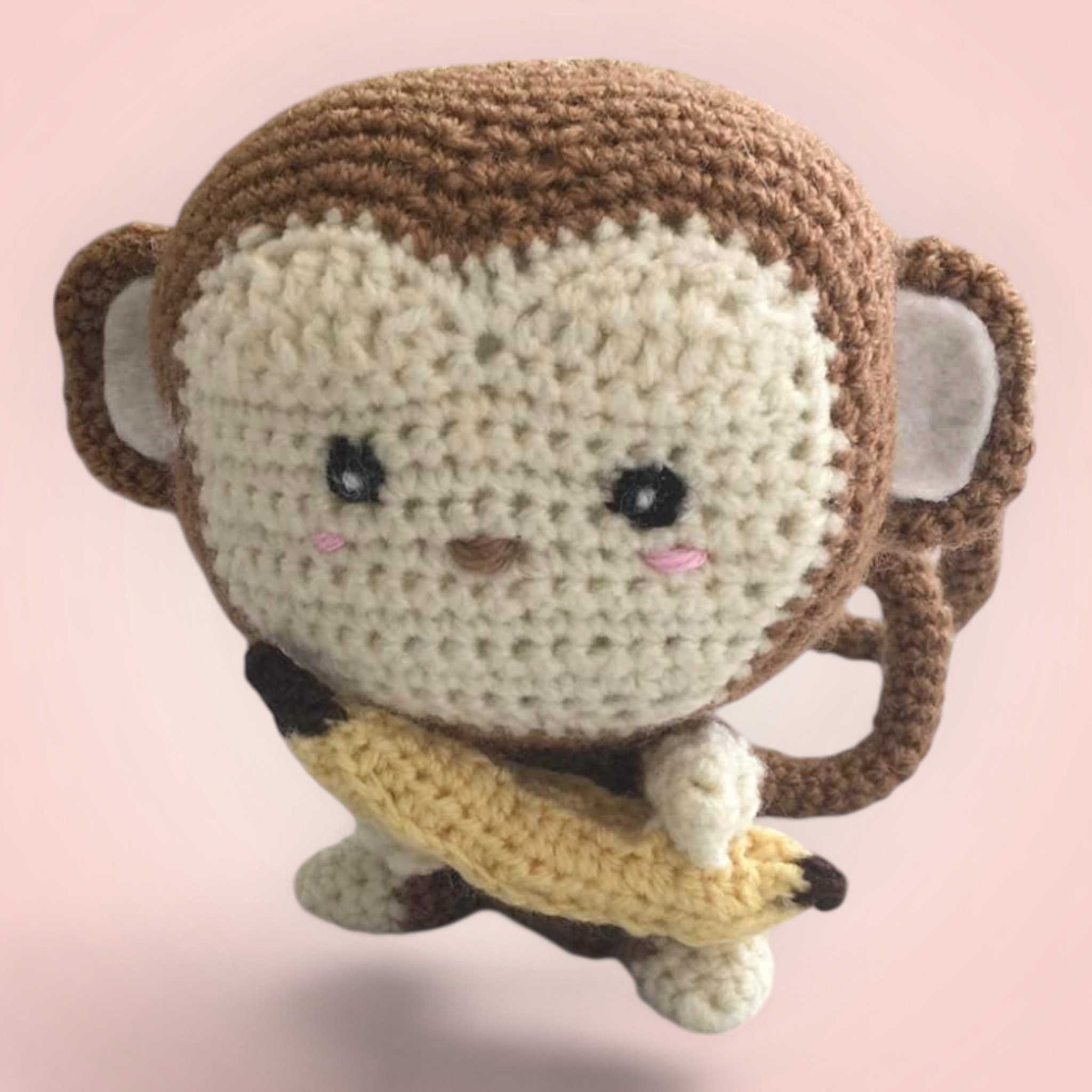 Adorable singe en peluche tenant une banane, fait main avec amour.