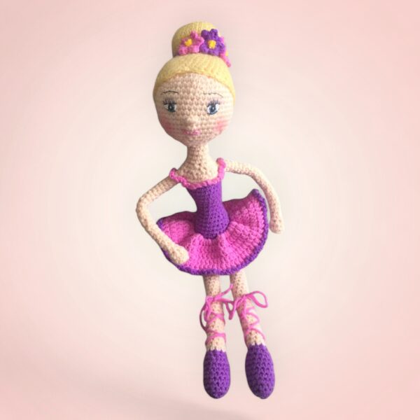 Gracieuse poupée danseuse en crochet avec une robe rose et violette.