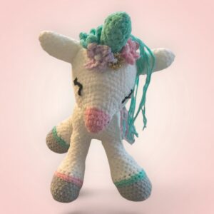 Magnifique licorne blanche en peluche, ornée de fleurs colorées.