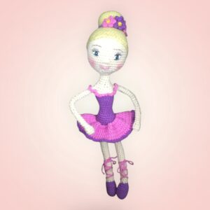 Charmante poupée ballerine en crochet, vêtue d'une robe rose et violette.