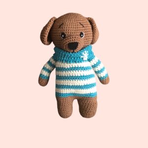 Adorable petit chien en crochet avec une marinière rayée.