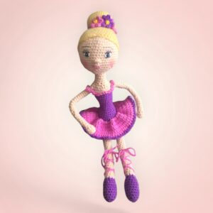 Gracieuse poupée danseuse en crochet avec une robe rose et violette.