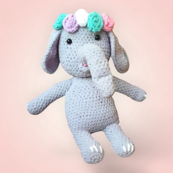 Charmant éléphant en crochet avec une couronne de fleurs.