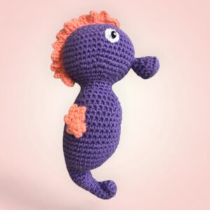 Charmant hippocampe violet et orange en crochet.