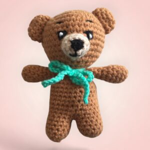 Adorable ours brun en crochet avec un nœud vert.