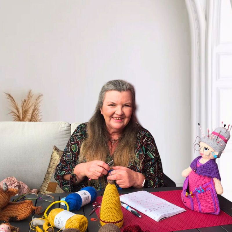 Mamy Laine crochète dans son atelier, entourée de ses créations
